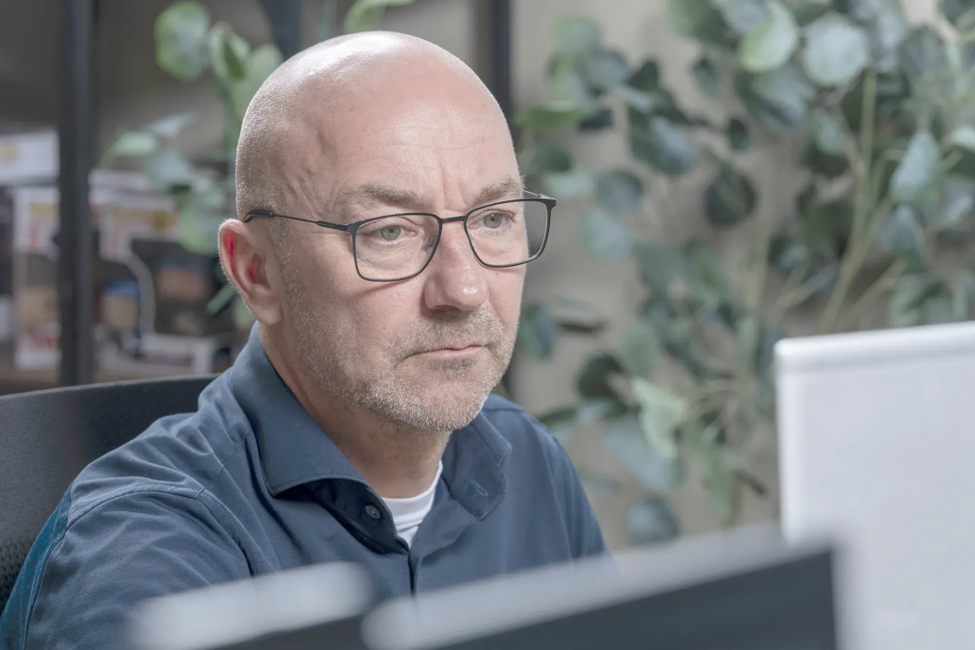 Collega van InfoReports geconcentreerd achter een scherm