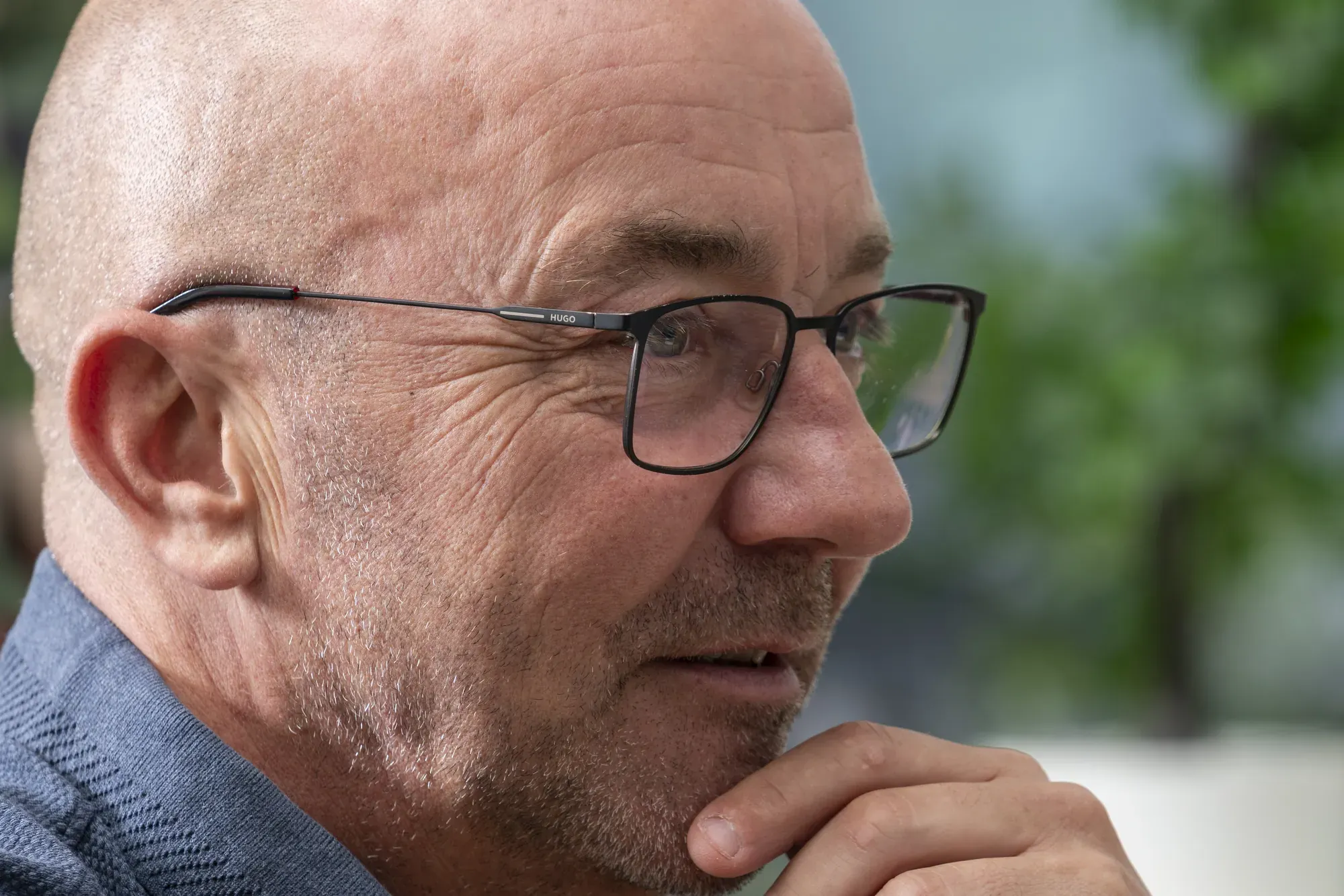 Medewerker van InfoReports luistert geconcentreerd, met de hand onder de kin
