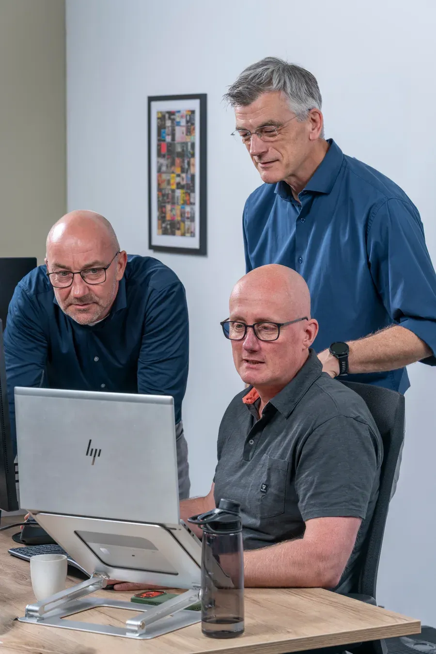 Het team van InfoReports kijkt samen naar data op een scherm